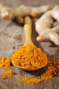 turmeric powder in wooden spoon